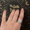 Ring aus der Sammlung "Exlibris" an der Hand ist ein silberner Schmuck mit einem Reliefornament.